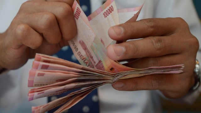 Ilustrasi menghitung uang Rupiah. (Foto: AFP/Adek Berry)