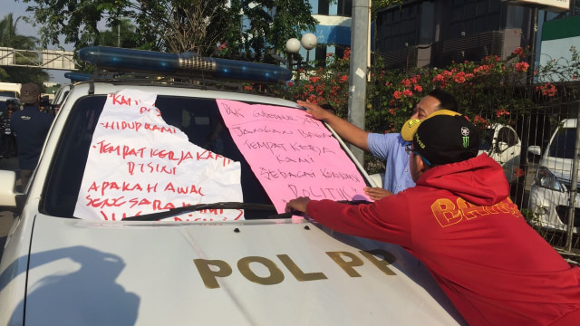 Mobil Pol PP ditempel spanduk oleh karyawan Alexis (Foto: Raga Imam/kumparan)