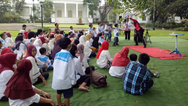 Jokowi dan penderita kanker menikmati sulap. (Foto: Jihad Akbar/kumparan)
