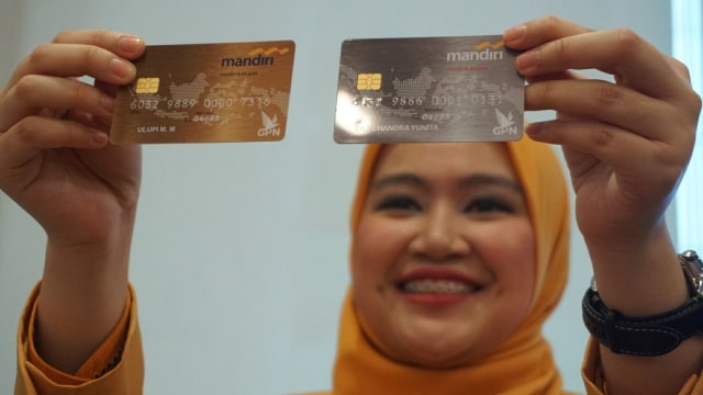 Karyawan Bank Mandiri mnunjukkan kartu chip sebagai pengganti kartu debit/ATM magnetik. Foto: Irfan Adi Saputra/kumparan