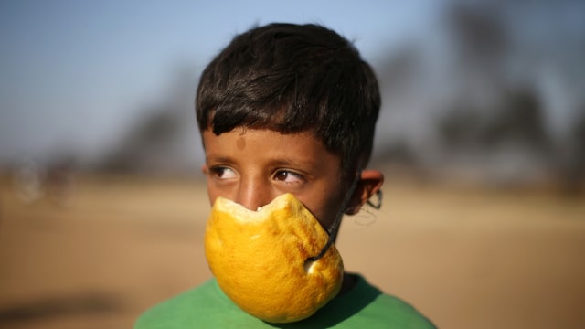 Masker gas Warga Gaza. (Foto: REUTERS/Ibraheem Abu Mustafa)