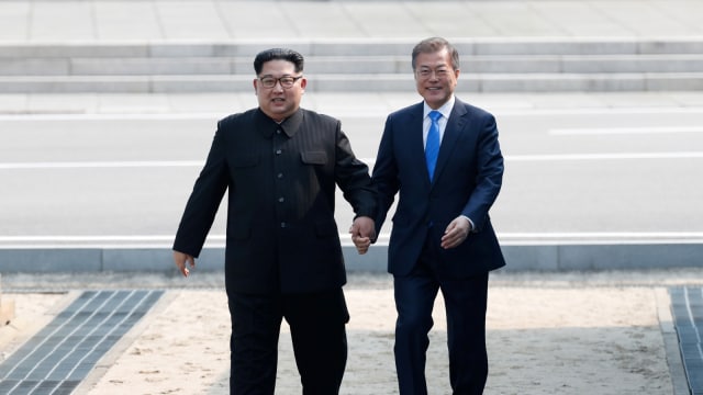 Kim Jong-un dan Moon Jae-in bergandengan. Foto: Korea Summit Press Pool/Pool via Reuters