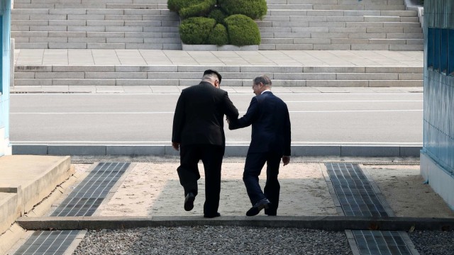 Kim Jong-un dan Moon Jae-in bergandengan. (Foto: Korea Summit Press Pool/Pool via Reuters)