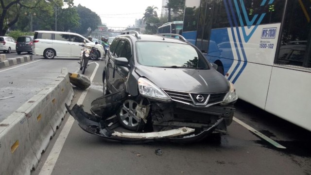 Kecelakaan mobil menabrak pembatas jalur TransJ. (Foto: Twitter @TMCPoldaMetro)