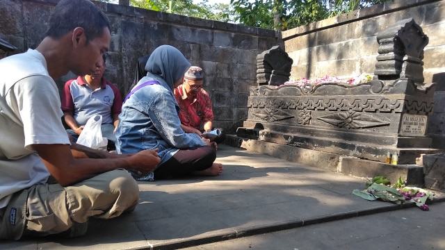 Mbah Asih nyekar di makam Mbah Maridjan (Foto: Arfiansyah Panji/kumparan)