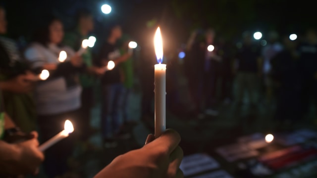 Nyala Lilin Untuk Korban Bom Surabaya (Foto: AFP/Adek Berry)