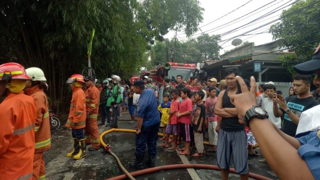 Warga menyaksikan petugas memadamkan api. (Foto: Twitter @BPBDJakarta)