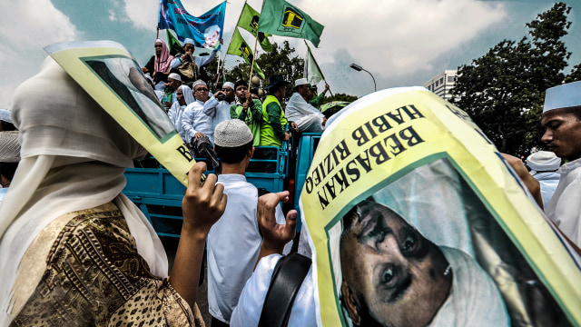 Massa membawa poster Rizieq Syihab. (Foto:  AFP/Jewel Samad)
