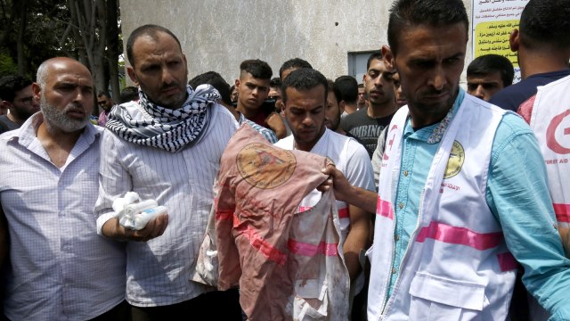 Ayah Razan al-Najjar membawa rompi saat pemakaman. (Foto: AFP/Said Khatib)