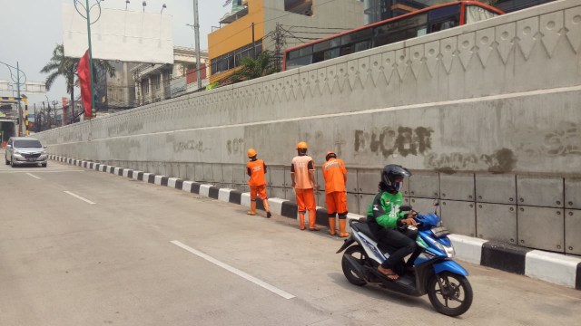 Pasukan Orange hapus coretan Underpass Mampang. (Foto: Ainul Qalbi/kumparan)