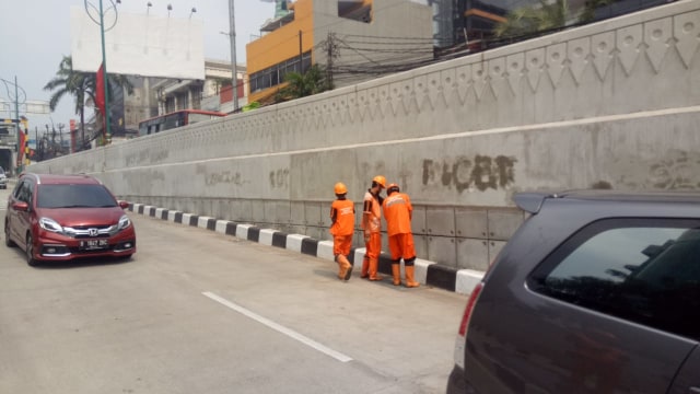 Pasukan Orange hapus coretan Underpass Mampang. (Foto: Ainul Qalbi/kumparan)
