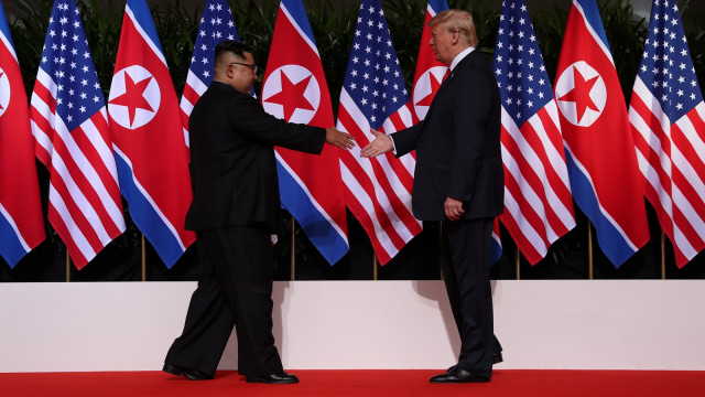 Kim dan Trump saling berjabat tangan. (Foto: Reuters/Jonathan Ernst)