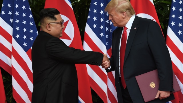 Kim dan Trump saling berjabat tangan (Foto: Anthony Wallace/Pool via Reuters)