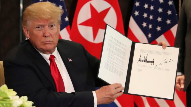 Trump menunjukan isi surat yang ditandatangani. (Foto: Reuters/Jonathan Ernst)