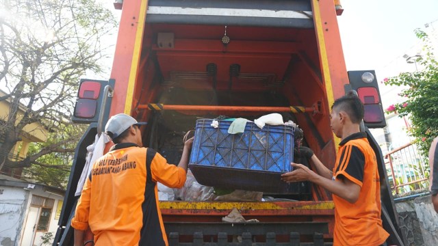 Petugas DLH angkut sampah dengan truk compactor (Foto: Jamal Ramadhan/kumparan)