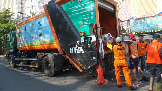Petugas DLH angkut sampah dengan truk compactor Foto: Jamal Ramadhan/kumparan