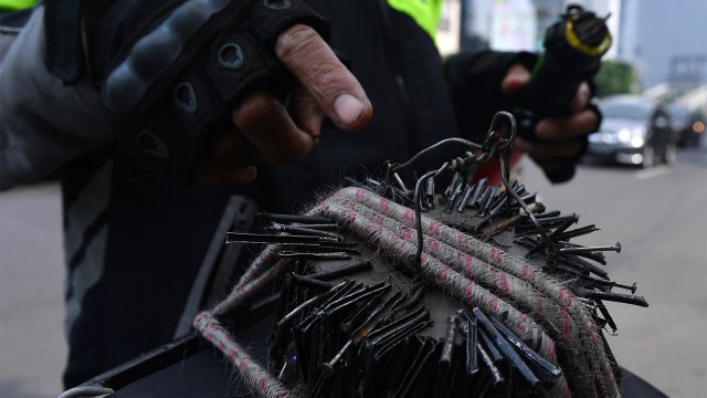 Relawan penyapu ranjau paku di Jakarta. Foto:  ANTARA FOTO/Sigid Kurniawan