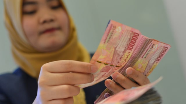 Petugas menghitung pecahan uang rupiah (Foto: ANTARA FOTO/Wahyu Putro)