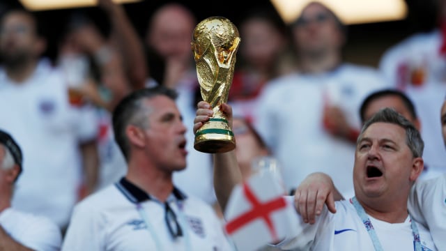 Suporter Inggris dengan trofi Piala Dunia. Foto: REUTERS/Lee Smith