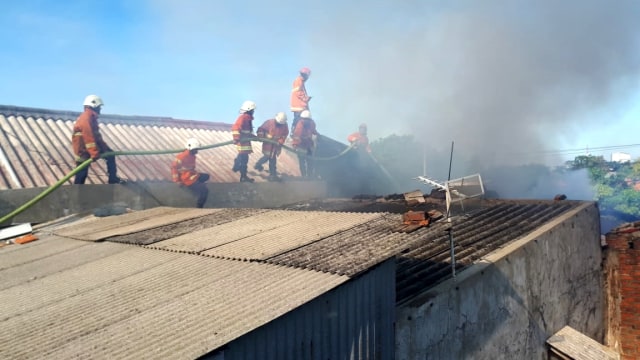 Petugas memadamkan api di salah satu rumah. (Foto: Dok. Istimewa)