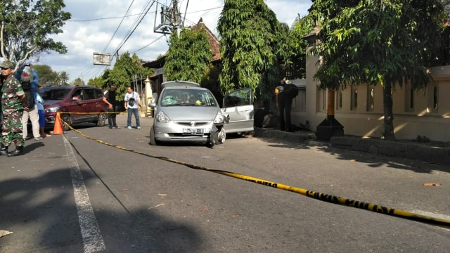 Petugas kepolisian memeriksa mobil ditembak polisi di Yogya. (Foto: dok. pandji)