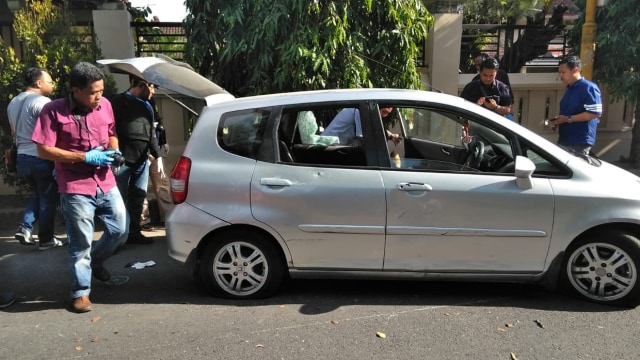 Petugas kepolisian memeriksa mobil ditembak polisi di Yogya. (Foto: dok. pandji)