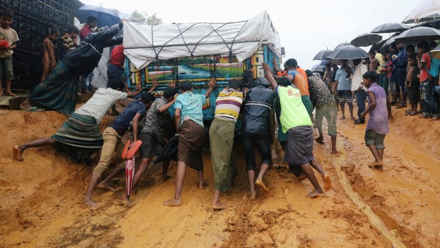 Pengungsi Rohingya mendorong truk karena terjebak dalam lumpur setelah hujan lebat di kamp Kutupalong di Cox's Bazar, Bangladesh. (Foto: REUTERS / Mohammad Ponir Hossain)
