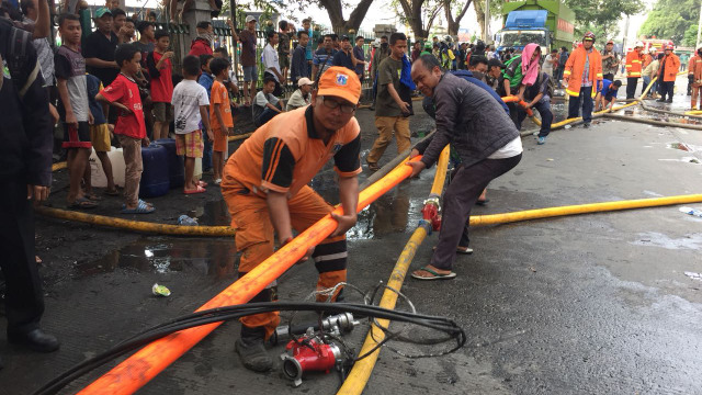 Petugas dibantu warag berusaha memadamkan kebakaran di Kampung Bandan. (Foto: Fachrul Irwinsyah/kumparan)