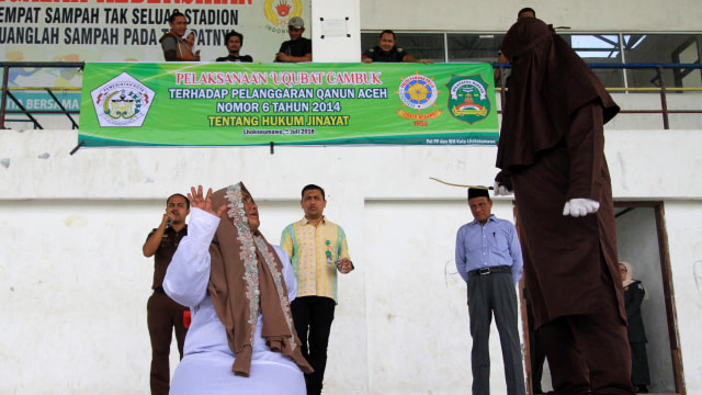 Terpidana pelanggar hukum syariat Islam menjalani hukuman cambuk (uqubat) di Stadion Tunas Bangsa, Lhokseumawe, Aceh, Kamis (5/7). (Foto: Antara/Rahmad)