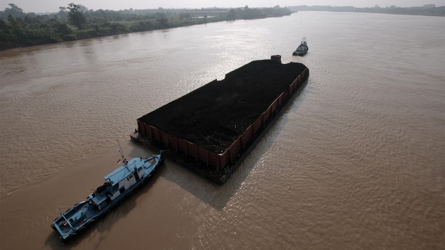 Kapal Tongkang pembawa batu bara melintasi aliran Sungai Batanghari di Muarojambi, Jambi. (Foto: ANTARA FOTO/Wahdi Septiawan)