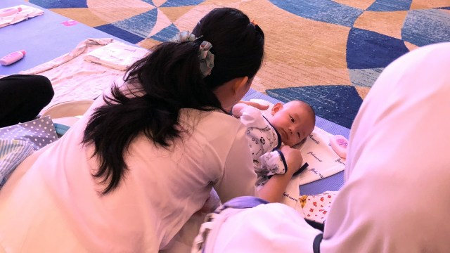 Proses pijat pada bayi dalam Gerakan Pijat Bayi Nasional. (Foto: Tamara Wijaya /kumparan)