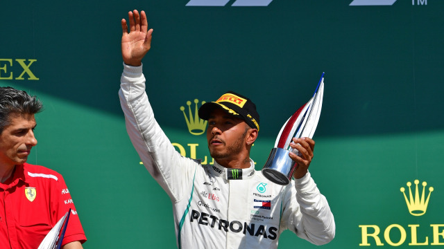 Lewis Hamilton merayakan naik podium di Inggris. (Foto: Andrej Isakovic / AFP)
