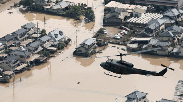 Sebuah helikopter melintas di atas lokasi banjir di Okayama, Jepang. (Foto: Mandatory credit Kyodo/via Reuters)