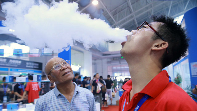 Seorang pria menghisap vape atau rokok elektronik. (Foto: AFP PHOTO )