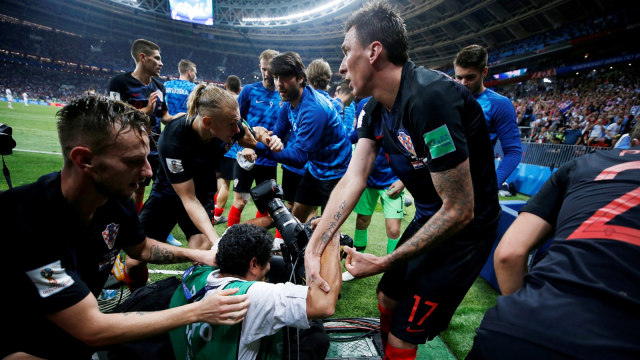 Pemain-pemain Kroasia membantu Yuri Cortez berdiri. (Foto: Carl Recine/Reuters)
