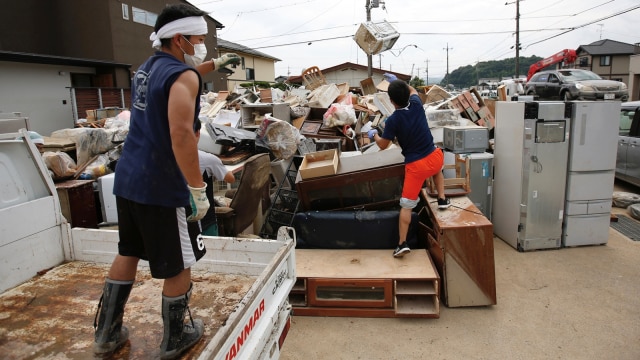 Penduduk setempat mencoba membersihkan reruntuhan di daerah yang terkena banjir di kota Mabi, Kurashiki, Jepang. (Foto: Reuters/Issei Kato)