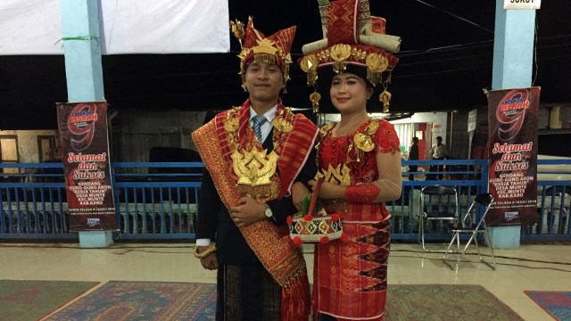Pasangan muda-mudi ini dipilih secara khusus sesuai marga pendiri kampung sebagai simbol pemimpin acara. (Foto: Helinsa Rasputri/kumparan)