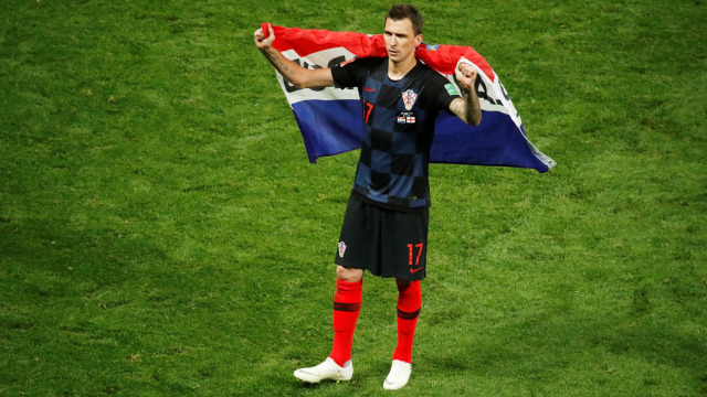 Mario Mandzukic membawa bendera Kroasia. (Foto: REUTERS/Christian Hartmann)