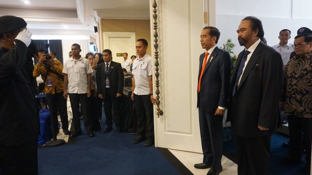 Presiden Joko Widodo (tengah) dan Surya Paloh (kanan) pada Kuliah Umum Presiden di Akademi Bela Negara NasDem. (Foto: Yudhistira Amran Saleh/kumparan)