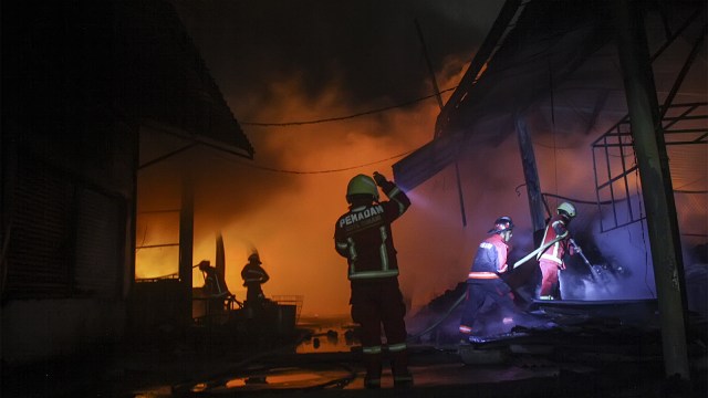 Petugas Pemadam berusaha memadamkan api yang menghanguskan bangunan. Foto: ANTARA FOTO/Amrizal