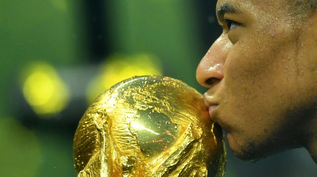 Kylian Mbappe mencium trofi Piala Dunia pertamanya. (Foto: Dylan Martinez/Reuters)