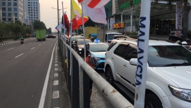 Bendera peserta Asian Games dipasang seadanya dengan bambu di Pluit (Foto: Fachrul Irwinsyah/kumparan)