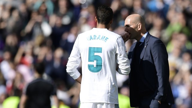Zinedine Zidane berbincang dengan Raphael Varane. (Foto: Javier Soriano/AFP)