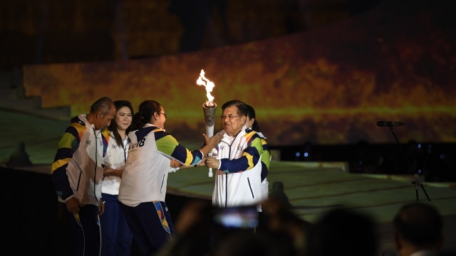 Wapres Jusuf Kalla menyerahkan api obor Asian Games 2018 yang telah disatukan kepada mantan atlet bulu tangkis Finarsih. (Foto: Antara/Ismar Patrizki)