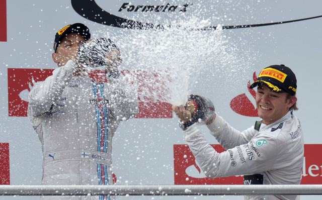 Nico Rosberg rebut kemenangan di GP Jerman 2014. (Foto: THOMAS KIENZLE / AFP)