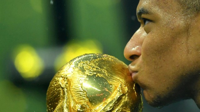 Mbappe mencium trofi Piala Dunia. (Foto: Reuters/Dylan Martinez)