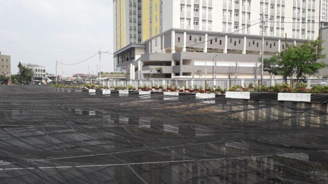 Kali Item di sekitar Wisma Atlet Kemayoran ditutupi jaring tipis untuk menutupi bau dan warna hitam airnya (Foto: Istimewa)