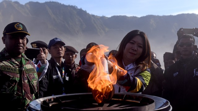 Legenda bulu tangkis Indonesia Susi Susanti (tengah) menyalakan kaldron dengan obor Asian Games 2018 di lautan pasir Gunung Bromo, Jawa Timur (Foto: ANTARA FOTO/Zabur Karuru)