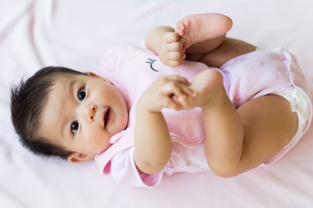 Bayi memegang jari-jari kakinya (Foto: Shutterstock)