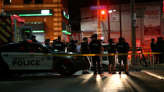 Polisi mensterilkan di lokasi penembakan di Toronto, Kanada, Minggu (22/7). (Foto: Reuters/Chris Helgren)